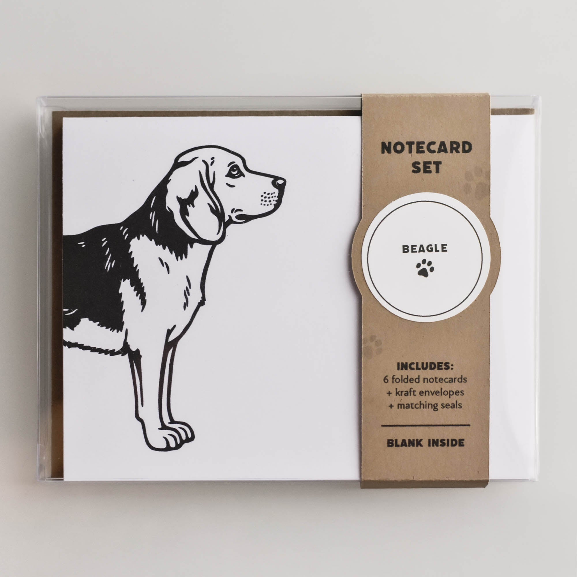 Packaged Beagle notecard set in a clear box with kraft belly band, showing the front card design and gift-ready presentation.