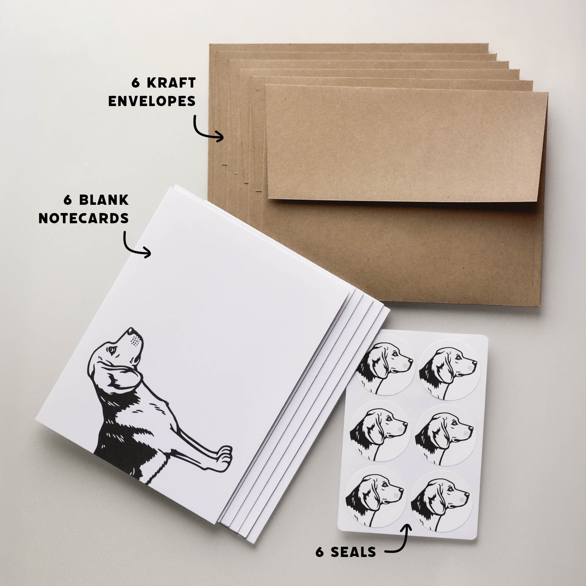Beagle notecard set contents showing six folded blank cards, six kraft envelopes, and six matching round seals with dog artwork.