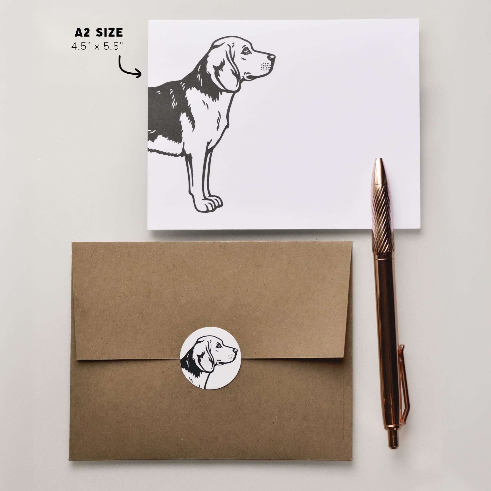 A2 Beagle notecard shown with kraft envelope, round seal, and pen prop to show card size and stationery set proportions.